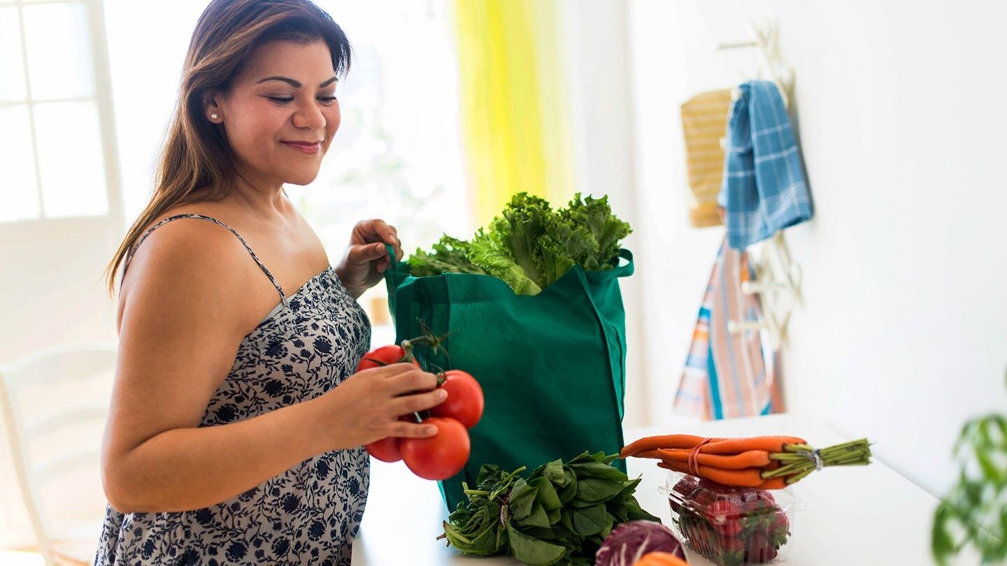 a woman taking groceries out of a bag to start a fad diet